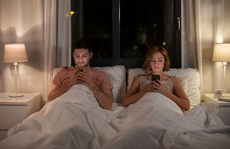 技术,互联网通信幸的夫妇晚上家用智能手机睡觉夫妇晚上家床上用智能手机图片