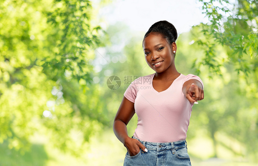 人,选择手势的快乐的非裔美国年轻女人指着你的绿色自然背景非裔美国女人指着你图片