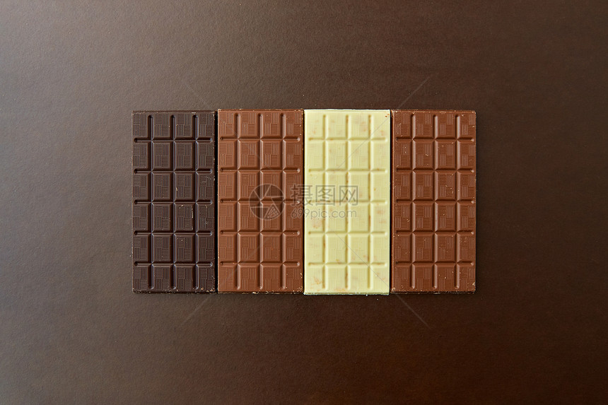糖果,糖果食品牛奶,黑巧克力白色巧克力棒棕色背景棕色背景下同种类的巧克力图片