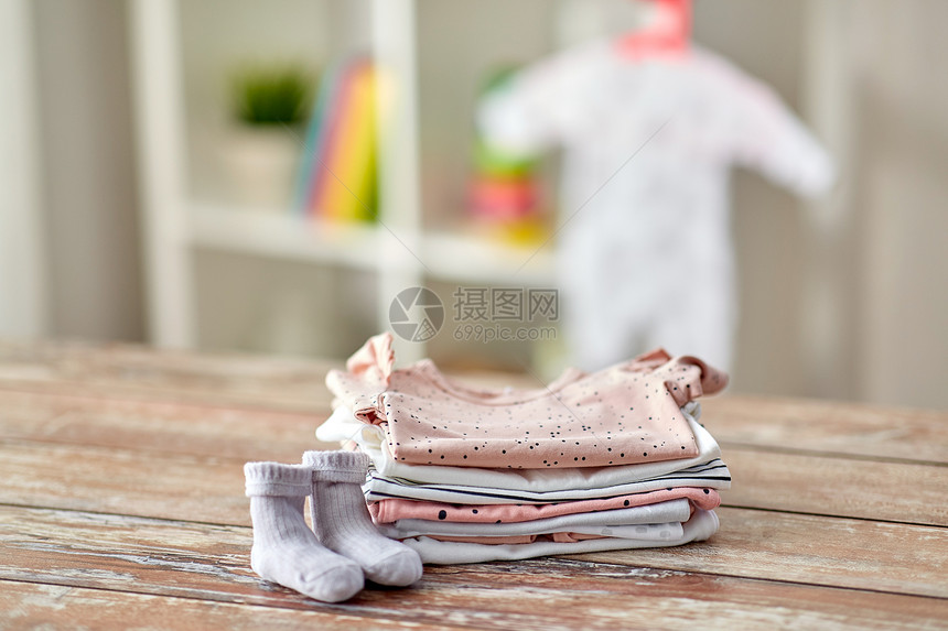 婴儿期服装婴儿衣服木制桌子家里家里木桌上的婴儿衣服图片