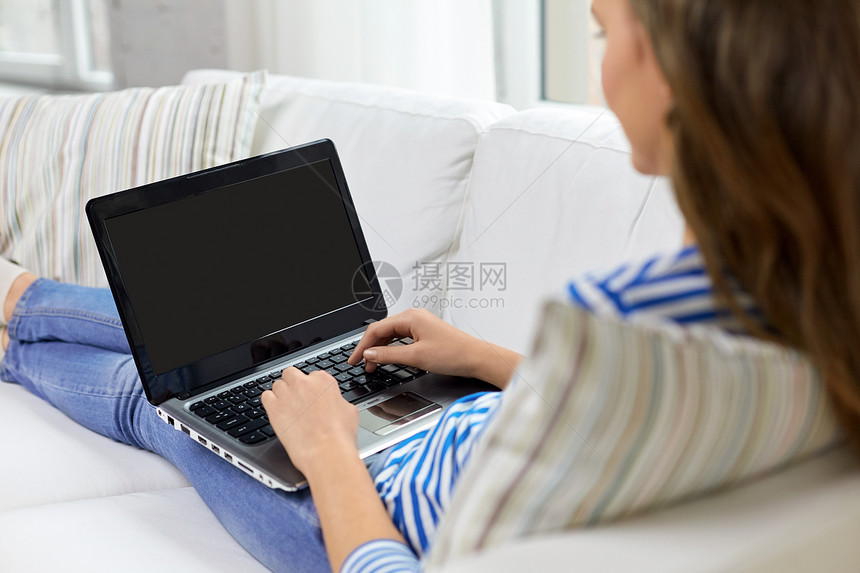 技术人的十几岁的女孩家里的笔记本电脑打字家里十几岁的女孩笔记本电脑上打字图片