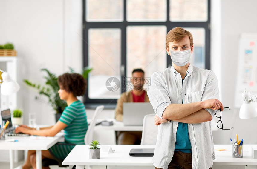 商业人的戴眼镜的男人戴着保护的医疗面具,以防止办公室的病疾病戴眼镜的男人戴着医用口罩办公室图片
