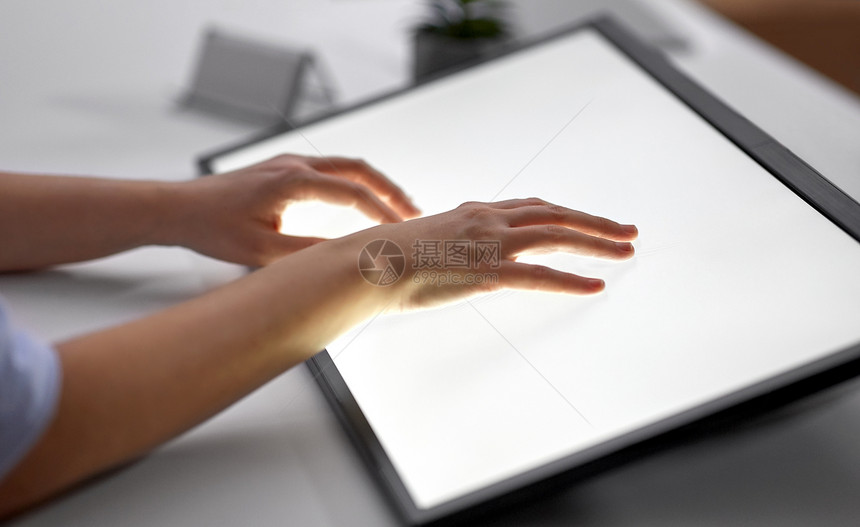 技术人的手LED轻平板电脑或触摸屏夜间办公室夜间办公室的LED灯片上图片
