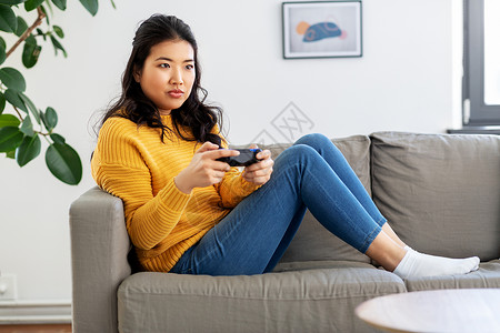 人与休闲的亚洲年轻妇女与游戏垫家里玩电子游戏亚洲女人家里玩游戏图片