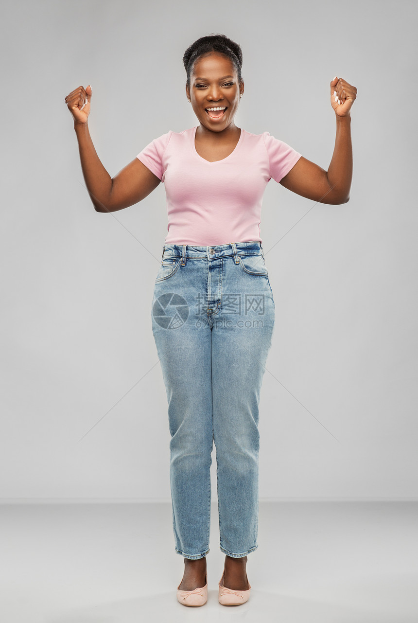 成功,胜利的姿态人们的快乐的年轻非洲裔美国妇女庆祝胜利的灰色背景快乐的非裔美国妇女庆祝成功图片