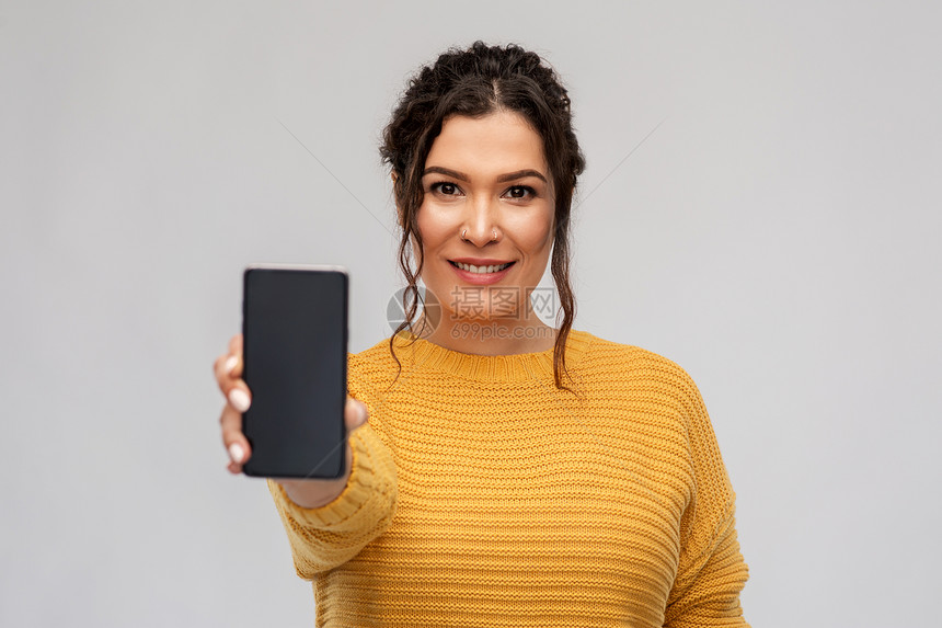 技术人的快乐的微笑女人展示智能手机灰色背景展示智能手机的快乐女人图片