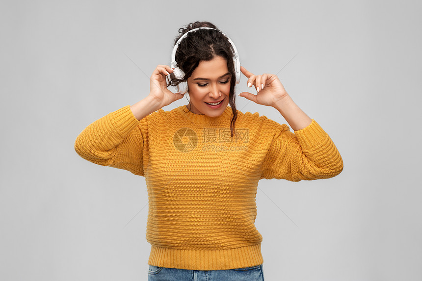 人,技术音频设备的快乐的微笑年轻妇女戴着穿孔的鼻子耳机听音乐灰色背景戴着耳机听音乐的快乐女人图片