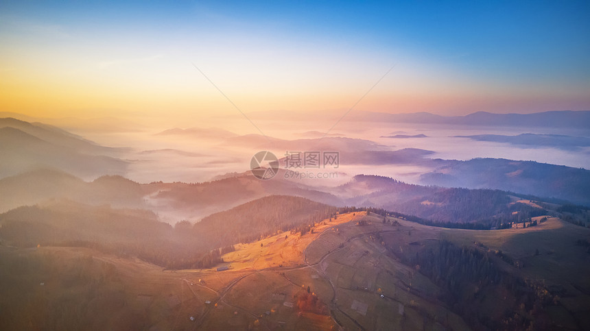 美丽秋山的空中全景日出山间雾谷上早上雾蒙蒙的林地乌克兰喀尔巴阡山脉图片