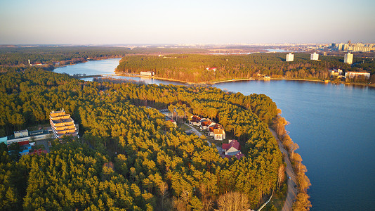 娱乐区大城市鸟瞰河岸与森林疗养院春天的阳光下四月的晚上,白俄罗斯明斯克附近的湖美丽的日落全景背景图片