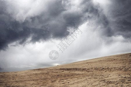 沙尘暴干燥的沙漠下,多云的天空下,乌云密布高清图片
