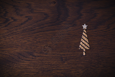 金色圣诞树,闪闪发光的木制背景,棕色圣诞节假期图片