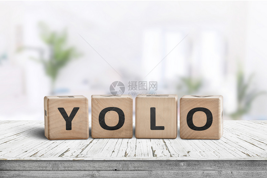 白色桌子上明亮的客厅里签上Yolo的缩写图片
