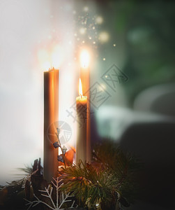 四支燃烧的蜡烛雪松树枝舒适的蜡烛照明室内图片