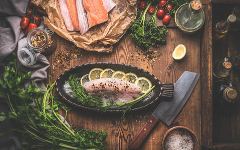 鱼烹饪准备与各种鱼片,烤盘鱼形乡村厨房桌子背景上面的风景图片