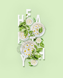 健康的生活方式单词健康与水碗与雏菊花绿叶浅绿色薄荷背景图片