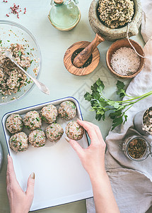 女手厨房的桌子背景上用草药香料做荞麦球,俯视图健康的自制食物图片