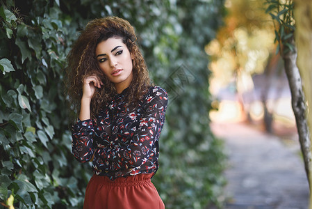 美丽的年轻阿拉伯女人,黑色卷发阿拉伯女孩街上穿休闲服图片