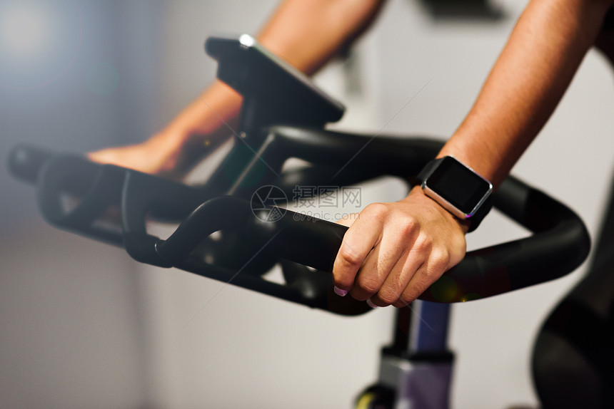 女人戴着智能手表在健身房锻炼图片