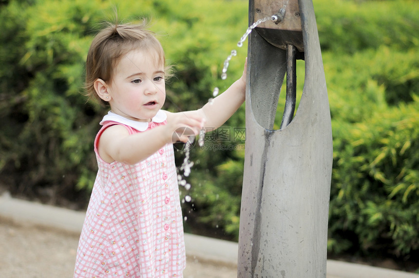 可爱的小女孩公园喷泉里喝水小女孩公园的喷泉里喝水图片