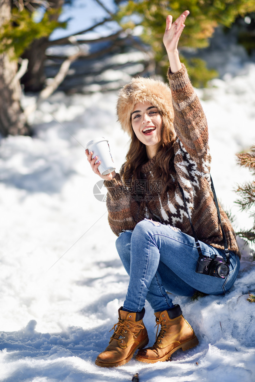 穿着冬天衣服的女喝热咖啡年轻的女人冬天享受雪山,内华达山脉,格拉纳达,西牙年轻的女人冬天享受雪山图片