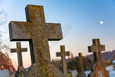 十字架教堂墓地上穿过墓碑,背景夜空中的满月图片