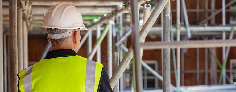 建筑工地上的男建筑工人戴着安全帽高vis背心全景图片