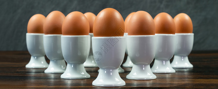 全景10个鸡蛋白色鸡蛋杯个木制桌子上的三角形排列图片