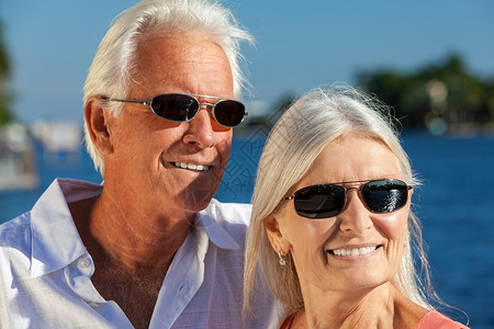 幸福的老年爱情男女浪漫的夫妇外面阳光下笑着戴着太阳镜海边或河边图片