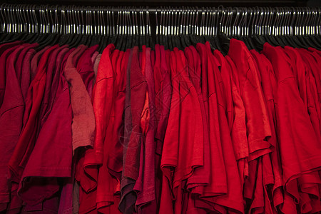 红色T恤挂商店衣柜壁橱栏杆上图片