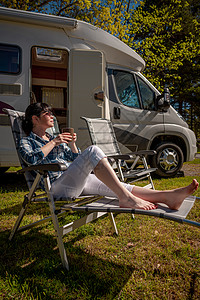女人站露营车旁边着杯咖啡房车度假家庭度假旅行,度假旅行汽车房车图片