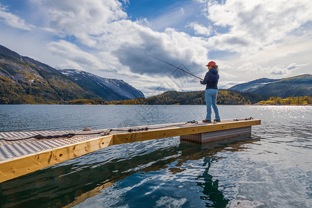 挪威钓鱼的女人钓鱼竿上挪威钓鱼拥抱当地生活方式的种方式无数的湖泊河流广阔的海岸线意味着杰出的机会背景图片