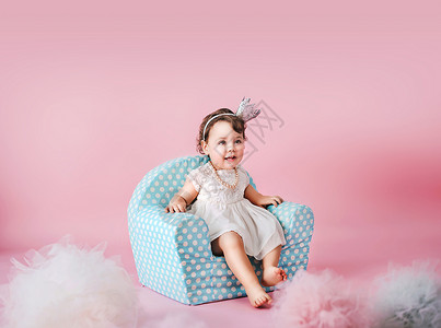 小可爱的女儿坐婴儿扶手椅上图片