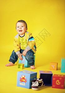 个带着堆玩具砖笑的小男孩的肖像图片