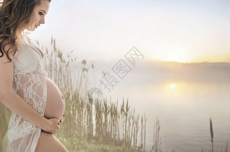 平静的孕妇湖边放松图片