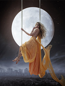 优雅的年轻女人大月亮的背景图片