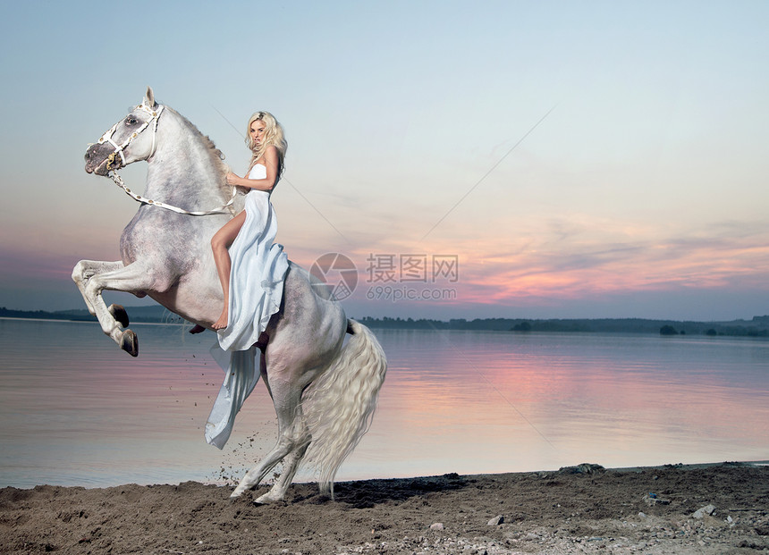 个金发女人骑着匹雄伟的马的肖像图片