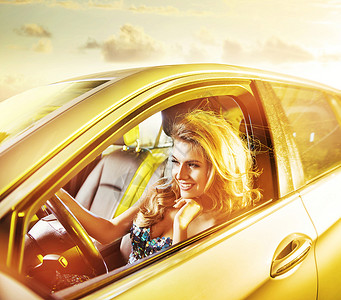 位驾驶豪华轿车的金发年轻女子的肖像图片