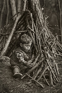 可爱的小男孩建造了个木制的庇护所图片