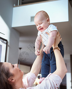 年轻的女人抱着她可爱的小儿子图片