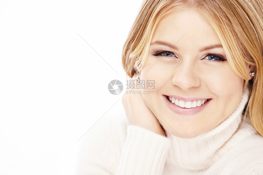 穿着白色毛衣的微笑的金发女郎的肖像图片