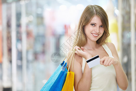 年轻迷人的女孩,商店里有购物信用卡图片