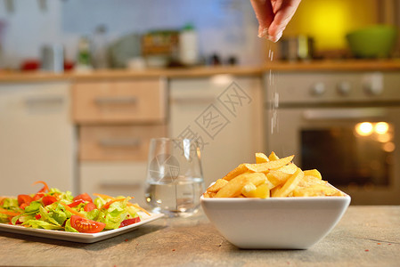 厨房桌子上有炸薯条沙拉高清图片