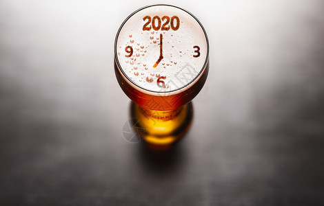 新年啤酒黑色桌子上啤酒玻璃泡沫上的2020符号,上面看新年2020啤酒图片