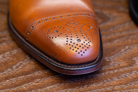 棕色的男式全纹皮鞋脚趾,特写全纹皮革棕色鞋的脚趾图片