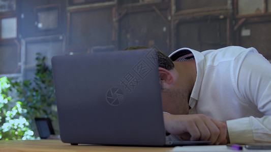 疲惫的商人睡小企业办公室的笔记本电脑上,为创业队商人睡笔记本电脑上图片