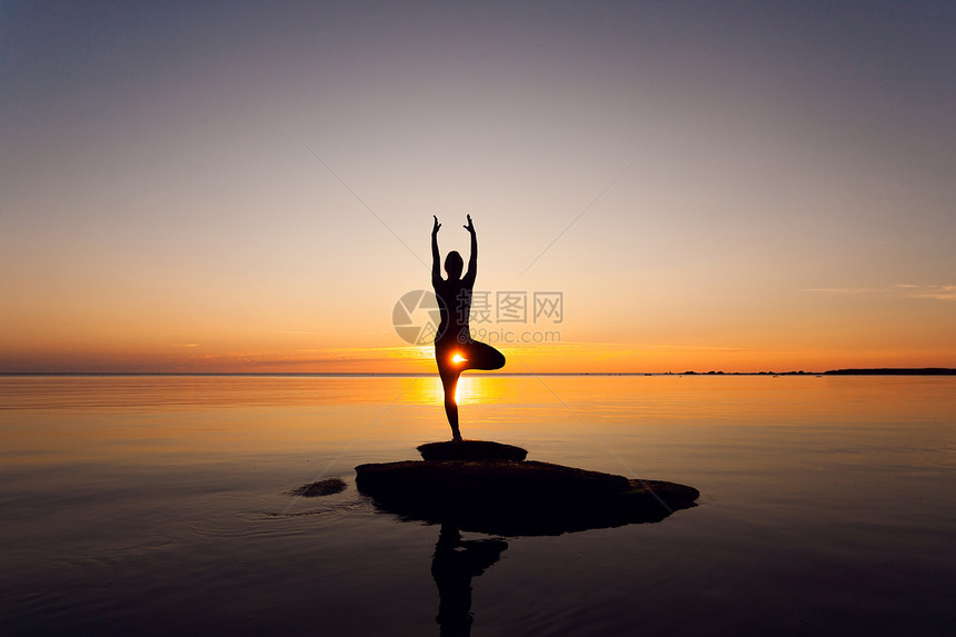 白种人健身妇女日落时海滩上练瑜伽高加索健身妇女练瑜伽图片