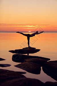 维拉巴达拉萨纳白种人健身妇女日落时海滩上练瑜伽高加索健身妇女练瑜伽背景