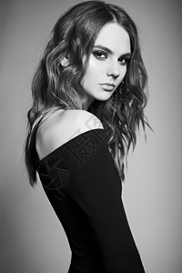 时尚工作室的年轻女子肖像黑色连衣裙卷亮的女士黑白照片图片