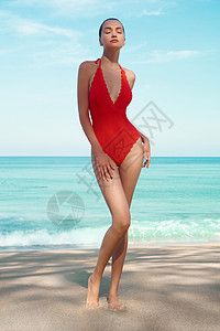 红色挂脖泳衣热带海滩上美丽感的女士时尚的女人,苗条完美的身材走蓝海前模特穿着红色泳装海洋附近放松年轻日光浴美女的肖像背景