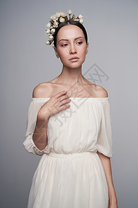 时尚工作室的年轻美女肖像,穿着希腊白色连衣裙,头上戴着鲜花时尚风格图片